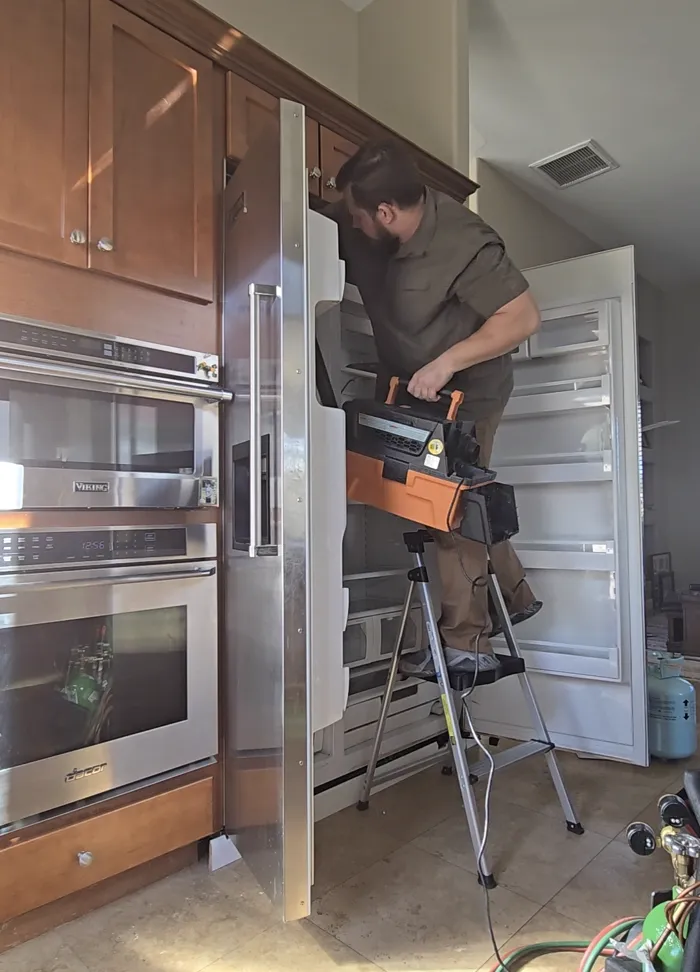 ProMaster technician servicing a built-in refrigerator column