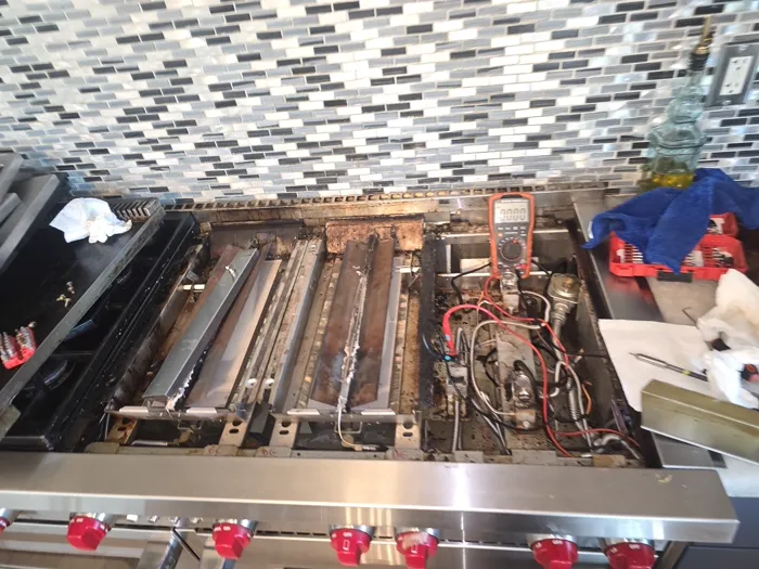 ProMaster technician testing a gas range with a multimeter